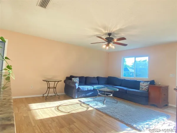 a living room with furniture and a ceiling fan