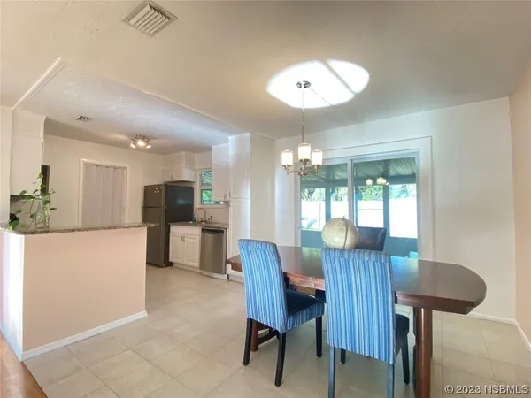 a view of a dining room with furniture and a chandelier