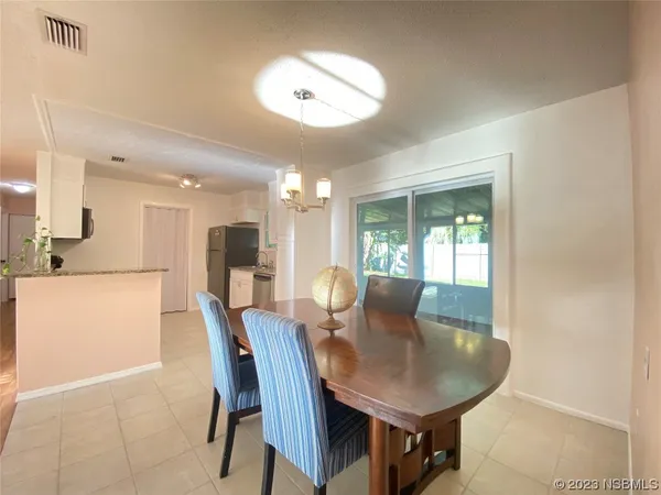 a view of a dining room with furniture and a potted plant