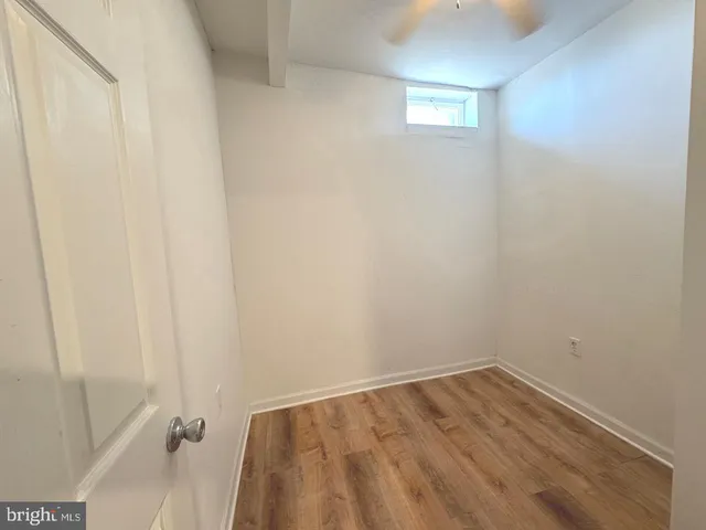 a view of a small space with wooden floor and a window