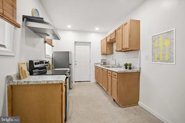 a kitchen with granite countertop a sink a counter top space stainless steel appliances and cabinets