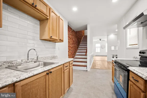 a kitchen with granite countertop a sink and a stove