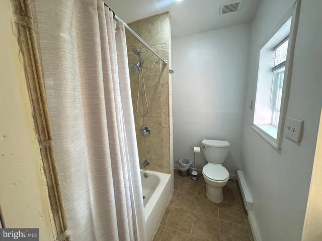 a bathroom with a sink a toilet and shower curtain