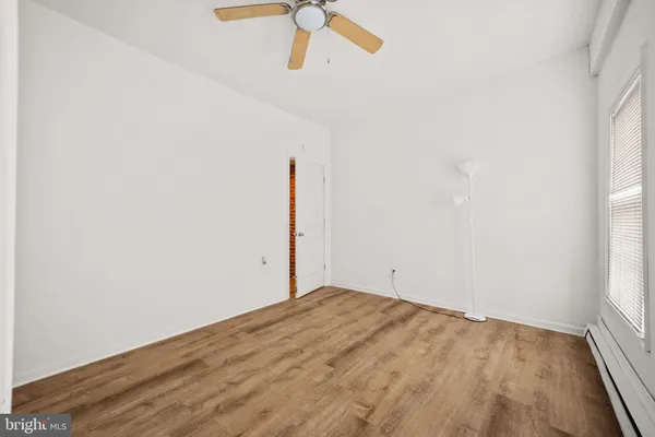 an empty room with a window and a ceiling fan