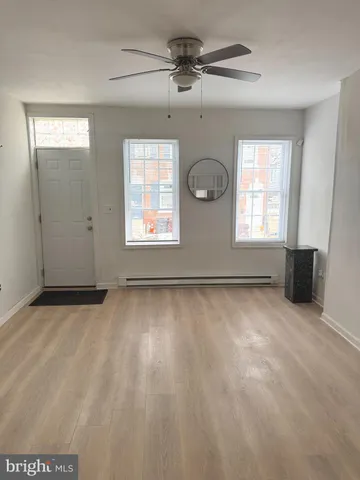 an empty room with windows and ceiling fan