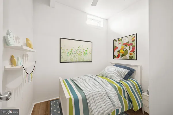 a bedroom with bed and paintings on the wall