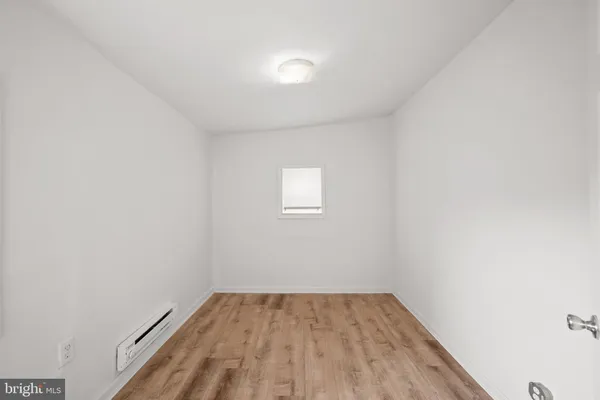 a view of a room that has wooden floor and white walls