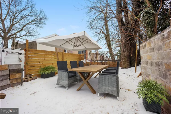a view of a patio with table and chairs with wooden fence and plants