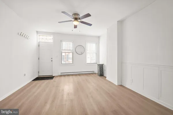 an empty room with windows and fan