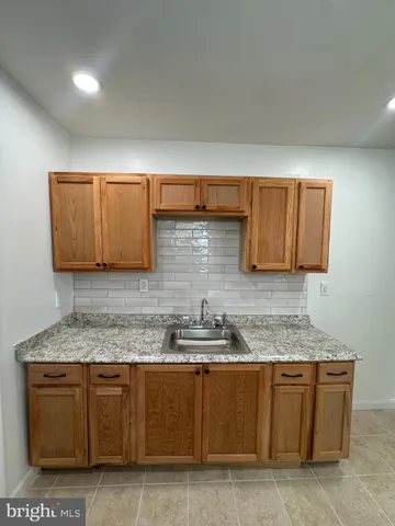 a kitchen with granite countertop a sink and cabinets