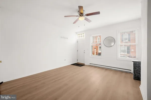 an empty room with windows and fan
