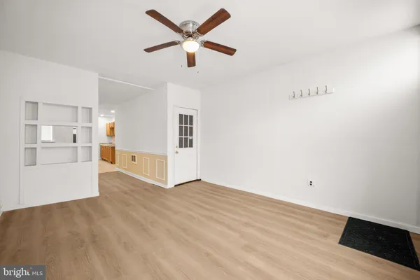 a view of a livingroom with wooden floor and a ceiling fan