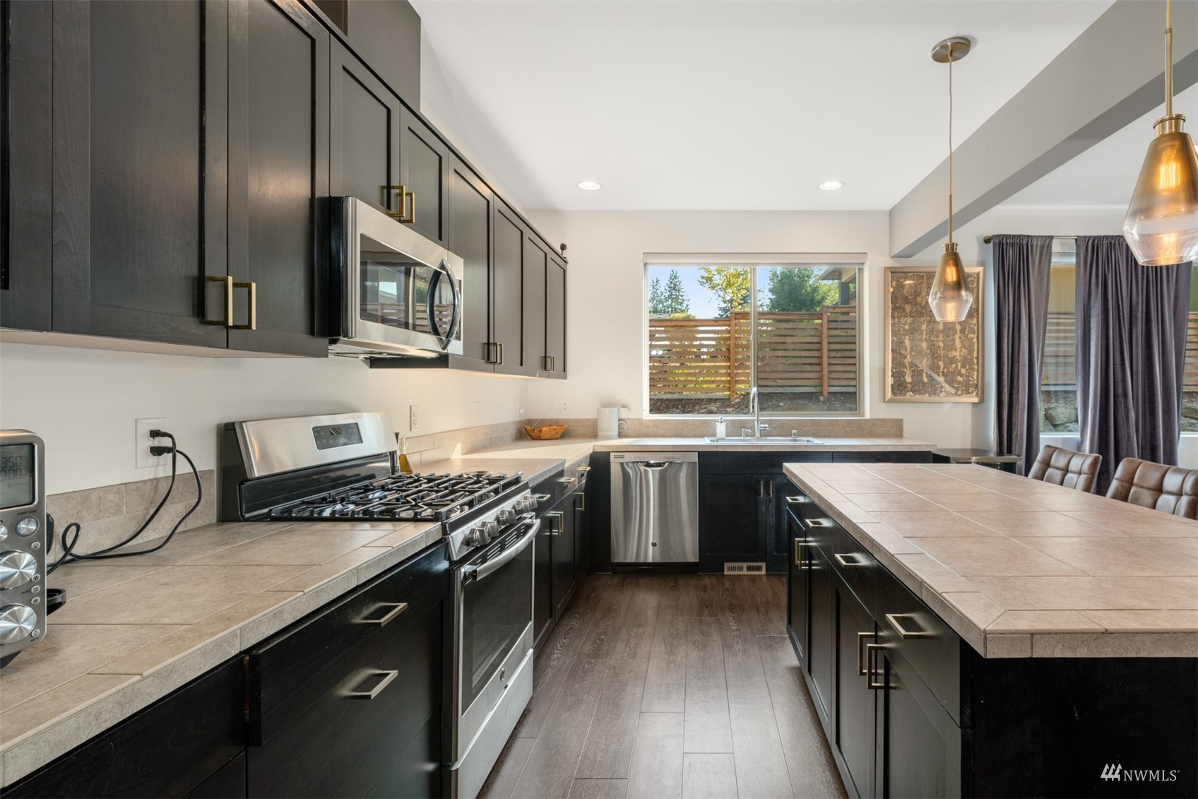 1413 South 28th Street Renton, WA 98055 - Photo 5 of 20 a kitchen with stainless steel appliances granite countertop a sink stove and cabinets