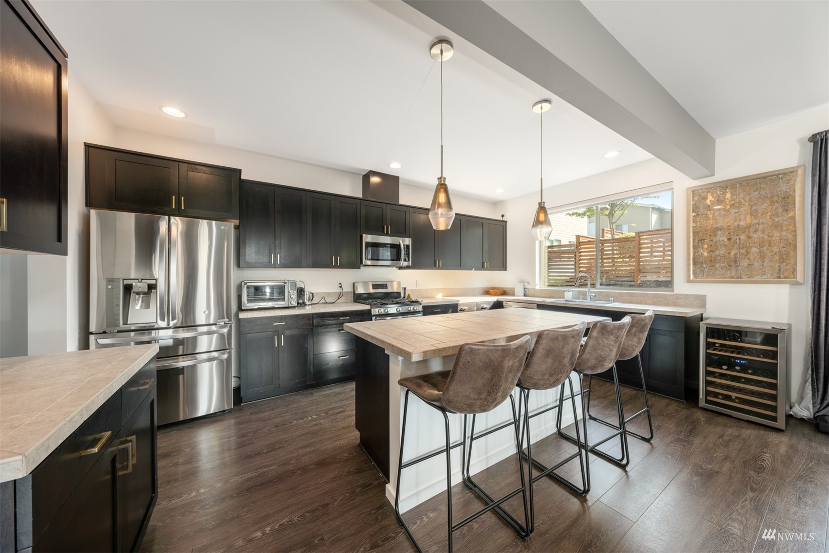 1413 South 28th Street Renton, WA 98055 - Photo 6 of 20 a kitchen with stainless steel appliances a stove a sink dishwasher a refrigerator and a dining table with wooden floor