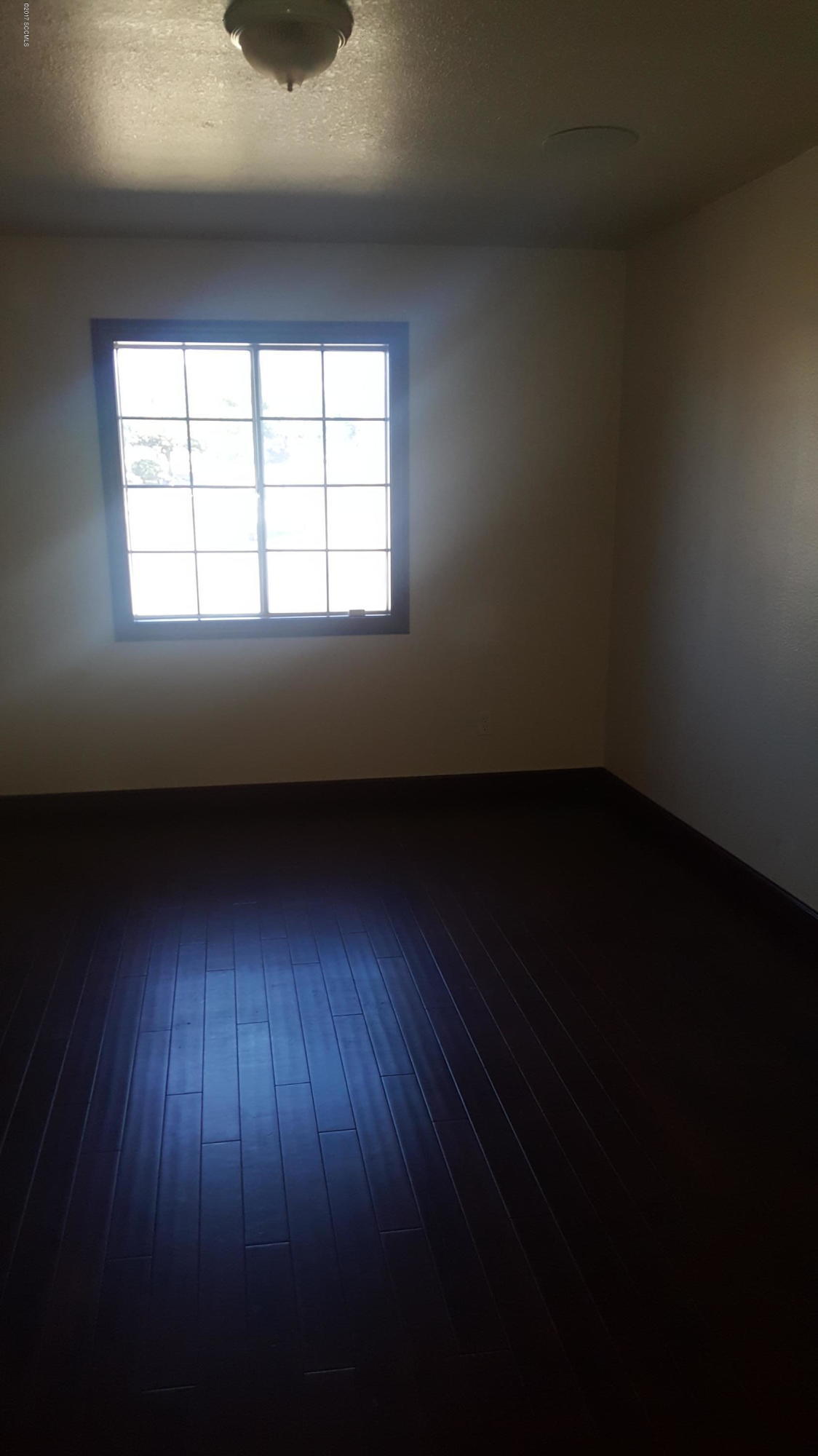 75 Highland Circle Rio Rico, AZ 85648 - Photo 8 of 19 wooden floor in an empty room with a window