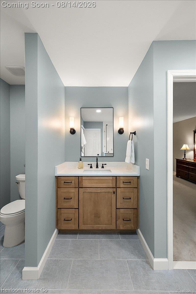 45697 Bryn Mawr Road Canton, MI 48187 - Photo 64 of 75 Bathroom vanity featuring a wood-finish cabinet with dark hardware, a white countertop, and an undermount sink with a matte black faucet