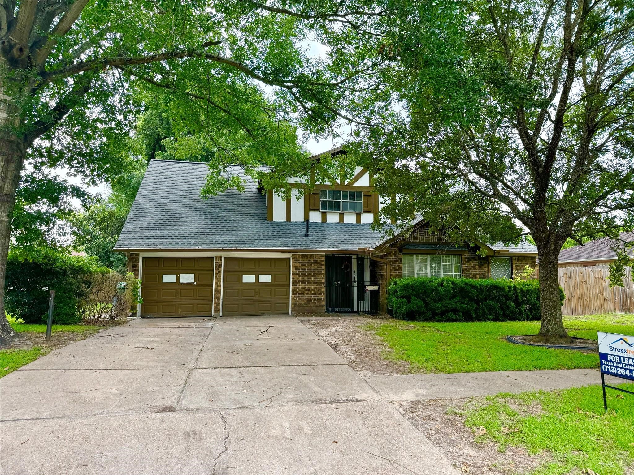 a front view of a house with a yard and trees