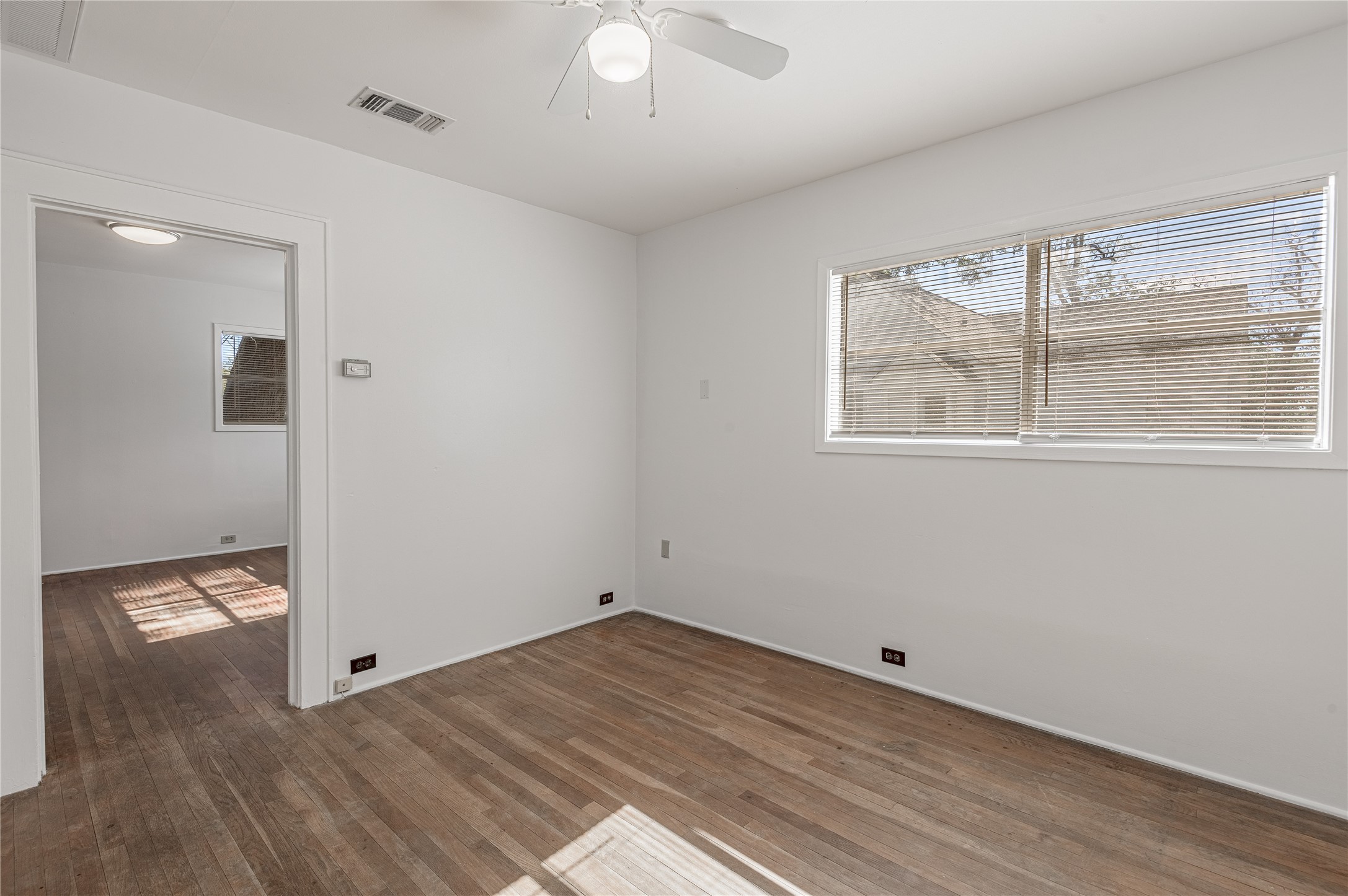 1312 20th Street, Unit GA Huntsville, TX 77340 - Photo 4 of 11 an empty room with wooden floor and windows