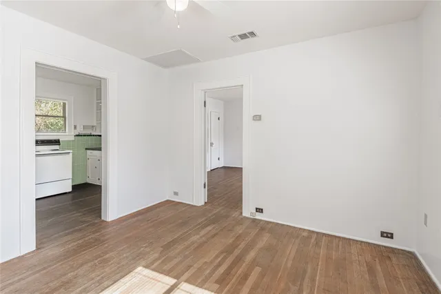a view of empty room with wooden floor