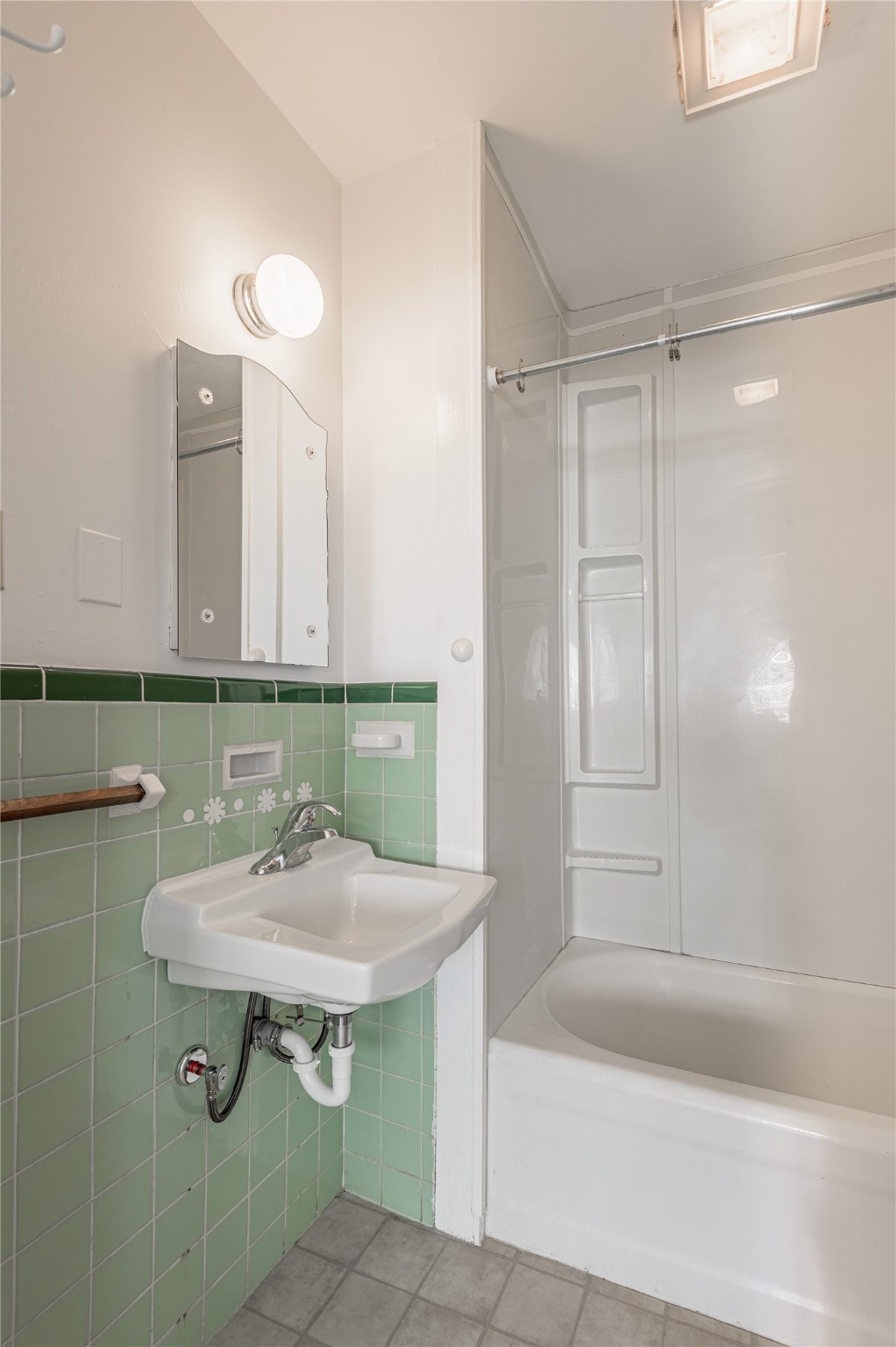 1312 20th Street, Unit GA Huntsville, TX 77340 - Photo 10 of 11 a bathroom with a sink a mirror and a bathtub