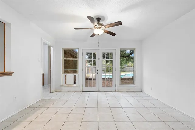 a view of an empty room with window and cabinet