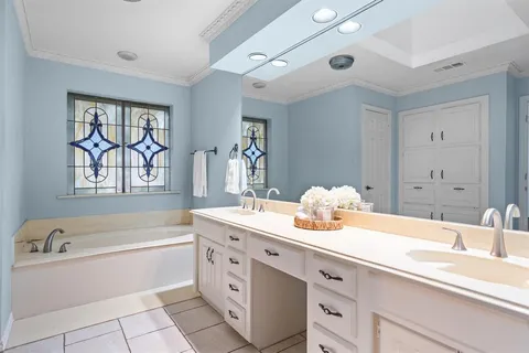 a spacious en suite bathroom with a granite countertop sink and a bathtub