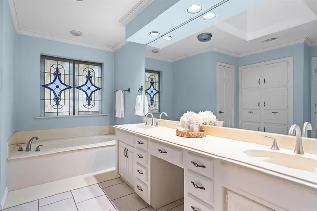 a spacious en suite bathroom with a granite countertop sink and a bathtub
