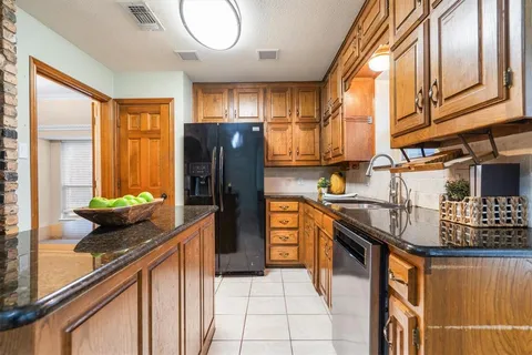 a kitchen with stainless steel appliances granite countertop a sink a stove and a refrigerator
