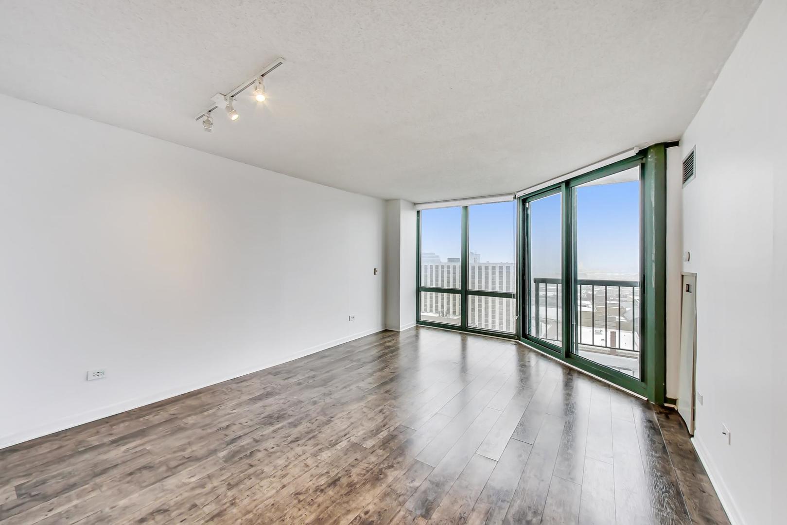 111 West Maple Street, Unit 1410 Chicago, IL 60610 - Photo 19 of 41 a view of an empty room with wooden floor and a window