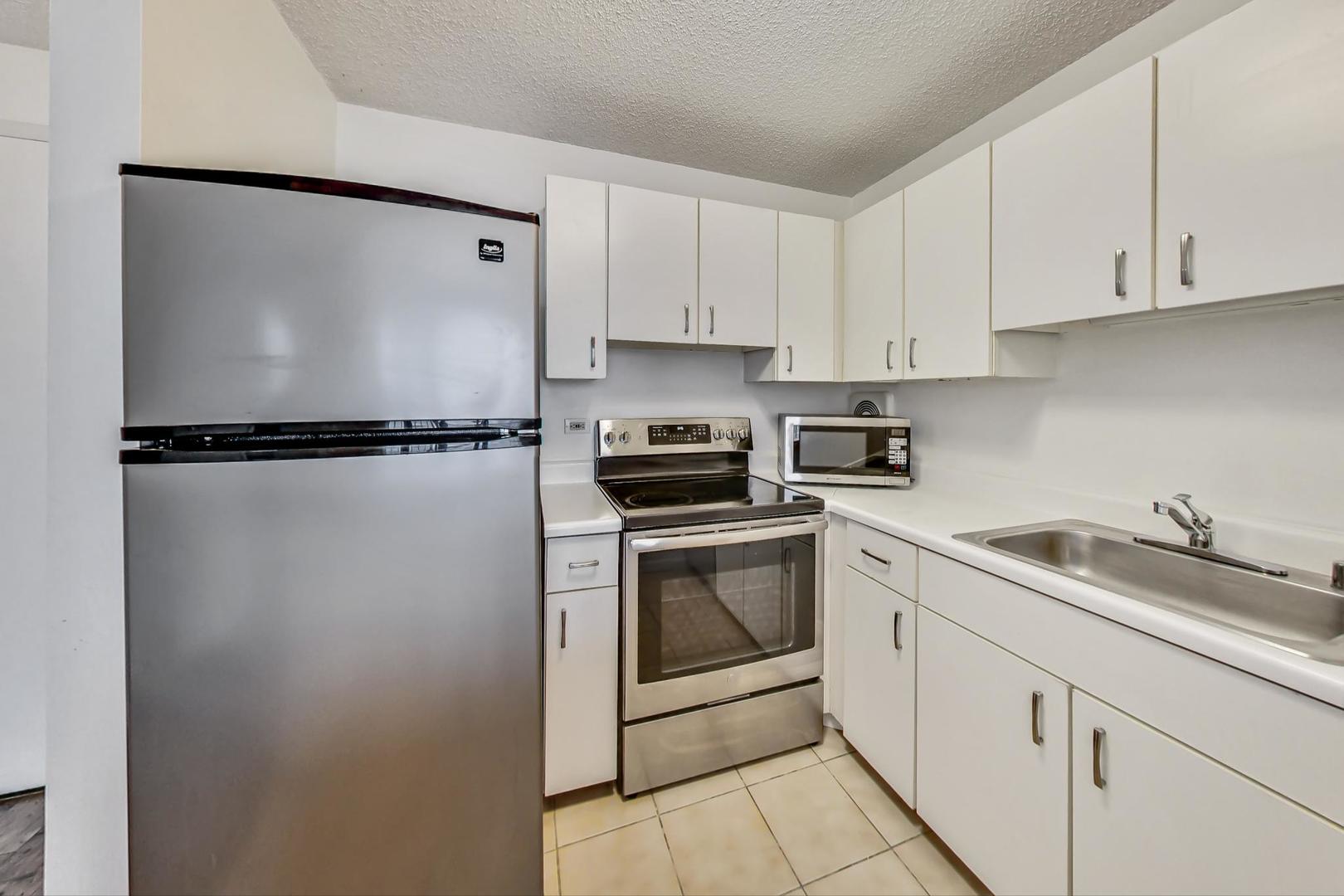 111 West Maple Street, Unit 1410 Chicago, IL 60610 - Photo 23 of 41 a kitchen with a refrigerator and white cabinets