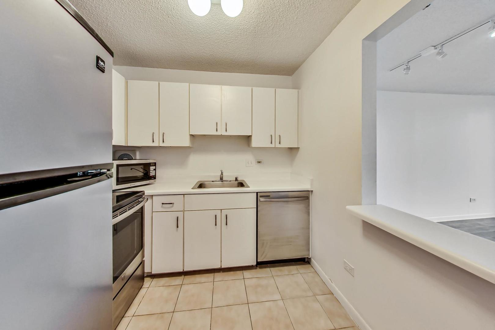 111 West Maple Street, Unit 1410 Chicago, IL 60610 - Photo 24 of 41 a kitchen with a stove sink and cabinets
