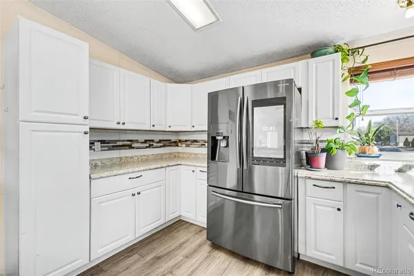 a kitchen with stainless steel appliances white cabinets and a refrigerator