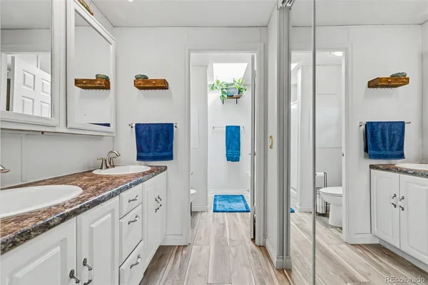 a spacious bathroom with a granite countertop sink a mirror and shower
