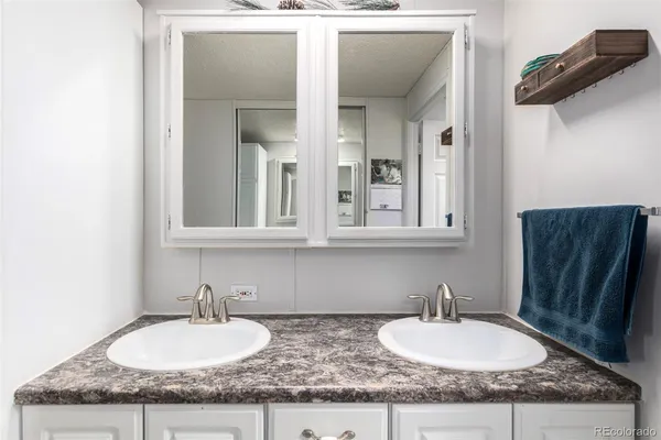 a bathroom with a granite countertop sink and a mirror