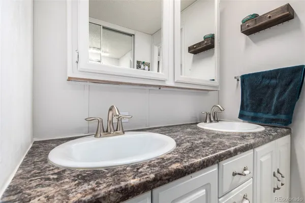 a bathroom with a granite countertop sink and a mirror