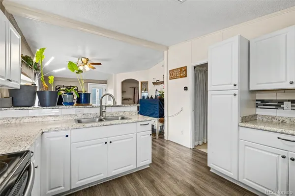 a kitchen with a sink cabinets and wooden floor