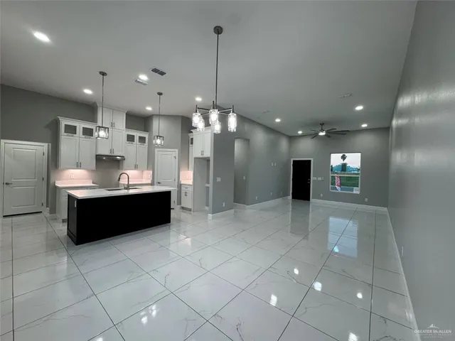 a kitchen with kitchen island stainless steel appliances a table chairs and refrigerator