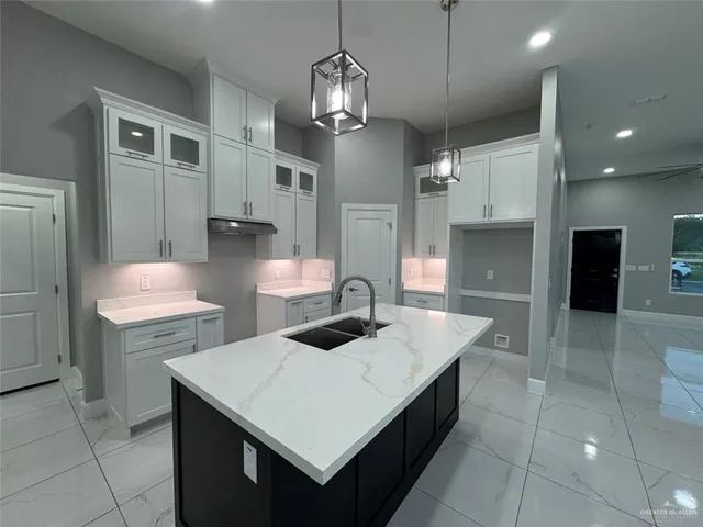 a large kitchen with kitchen island granite countertop a large counter top and stainless steel appliances