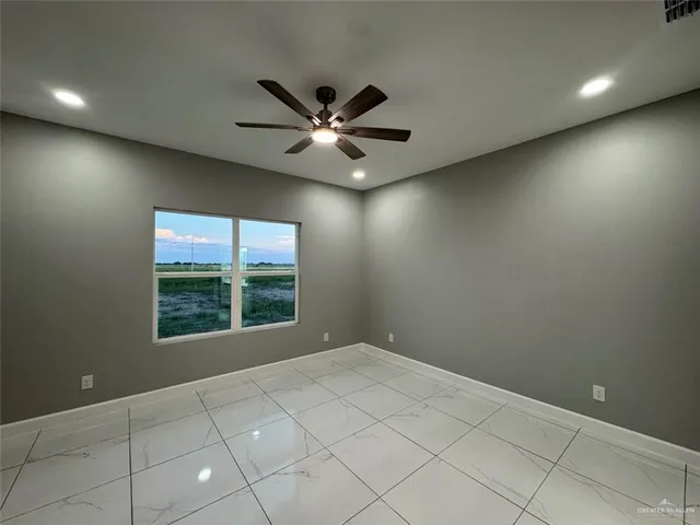 an empty room with fan and entrance