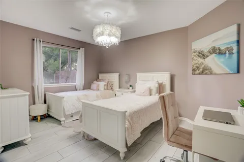 a bedroom with a bed and a chandelier