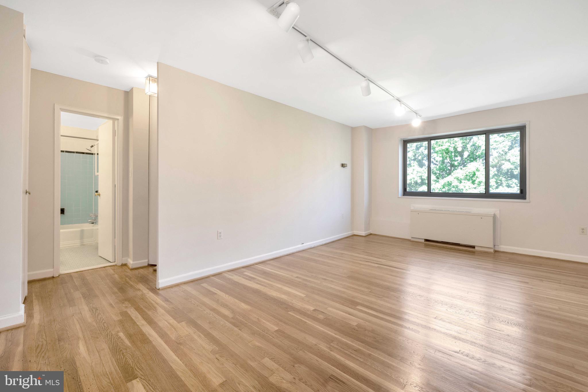 1200 South Arlington Ridge Road, Unit 503 Arlington, VA 22202 - Photo 4 of 17 an empty room with wooden floor and windows