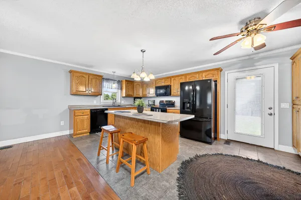 a kitchen with stainless steel appliances granite countertop a sink a stove cabinets and wooden floor