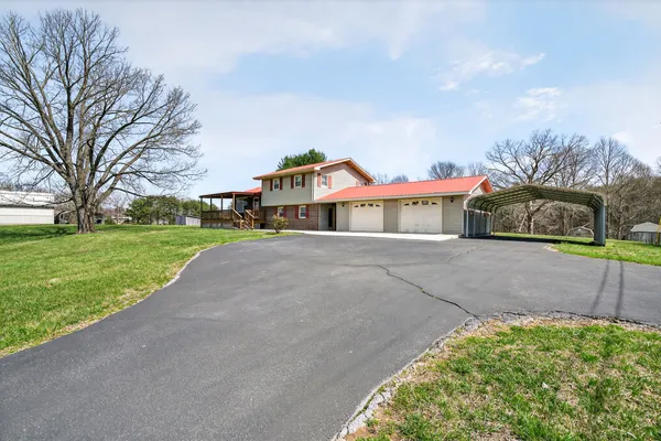 a view of a house with a yard and garage