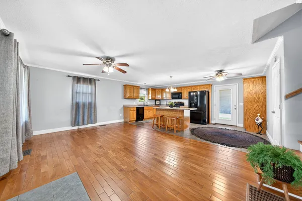 a kitchen with stainless steel appliances kitchen island granite countertop a sink a stove a dining table and chairs