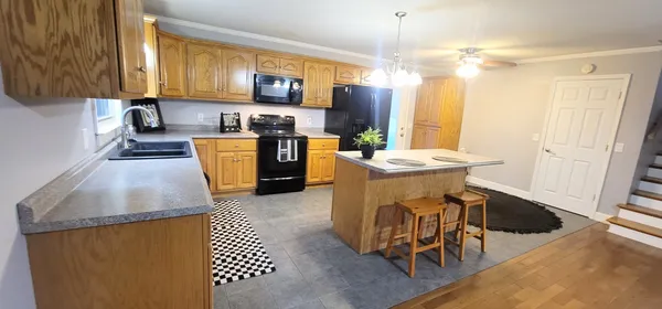 a kitchen with stainless steel appliances granite countertop a stove top oven a sink dishwasher and a refrigerator