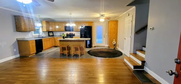 a kitchen with stainless steel appliances granite countertop a stove top oven a sink dishwasher and cabinets with wooden floor