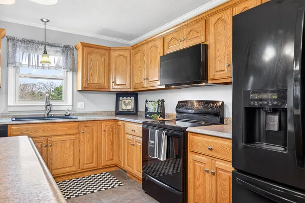 a living room with stainless steel appliances kitchen island granite countertop furniture and a fireplace