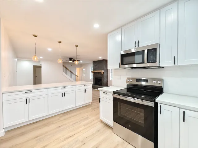 a kitchen with stainless steel appliances a stove microwave and sink