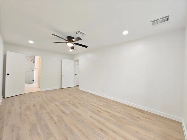wooden floor in an empty room with a ceiling fan