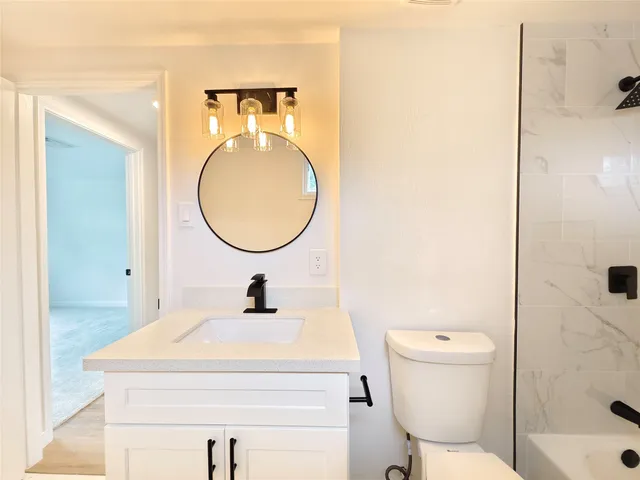 a bathroom with a sink toilet and a mirror